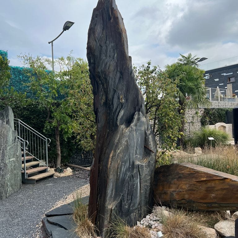 Feature image for Black Schist - Megaliths and Standing Stones. The image shows this product being used for garden accents and sculpture &amp; carvings. The surface finish shown is natural cleft. The dominant color shown is black.