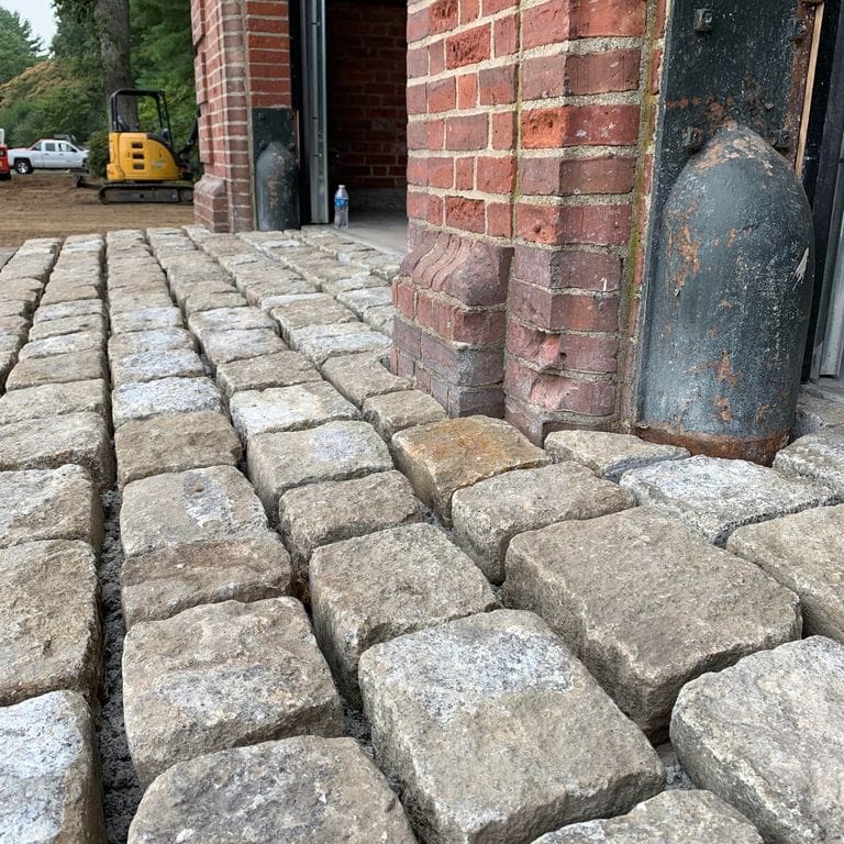 Best close-up image for Reclaimed New England Cobblestones - Jumbo Wide Side. The image shows this product being used for driveway pavers and driveway aprons. The surface finish shown is . The dominant color shown is gray. The color mix creates a cool feeling.