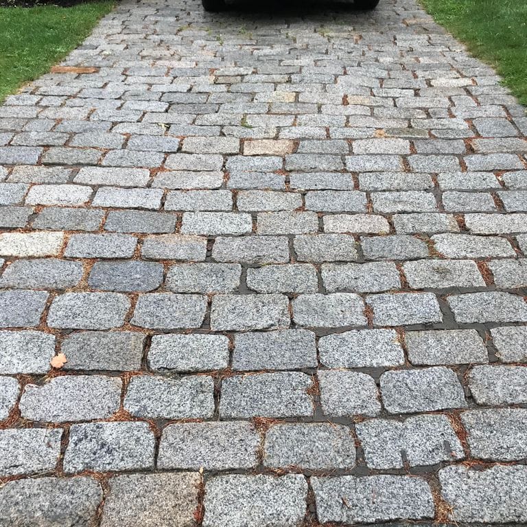 The image shows this product being used in a driveway pavers application.