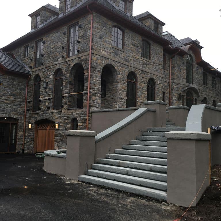 Application image for New England Fieldstone - Barre Dark Veneer. The image shows this product being used in a full bed veneer application. The surface finish shown is weathered. The dominant color shown is gray. The color mix creates a warm feeling.