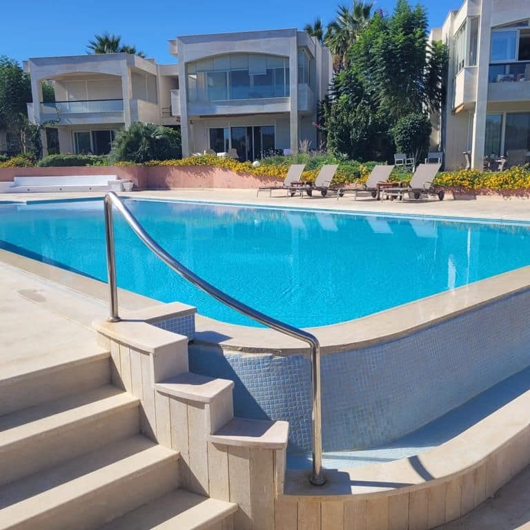 Application image for Moon Beige Limestone - Flamed Pavers. The image shows this product being used for pool coping and pool deck pavers. The surface finish shown is flamed. Dominant colors shown are beige, tan and cream. The color mix creates a warm feeling. Contains mineral inclusions.