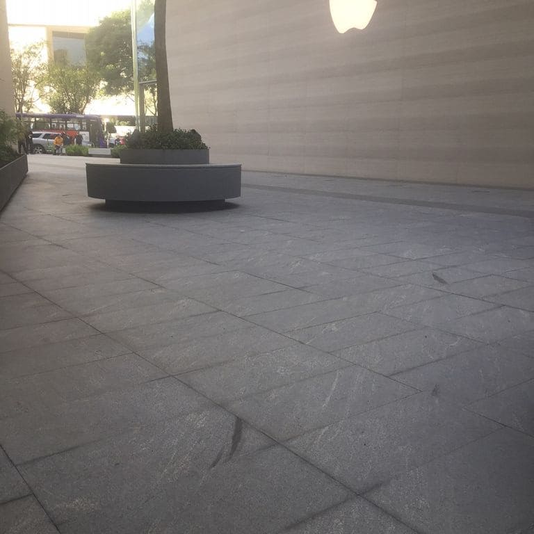 Application image for Brazilian Lucerna Gneiss - Flamed Pavers. The image shows this product being used in a public area application. The surface finish shown is flamed. The dominant color shown is gray. The color mix creates a warm feeling.