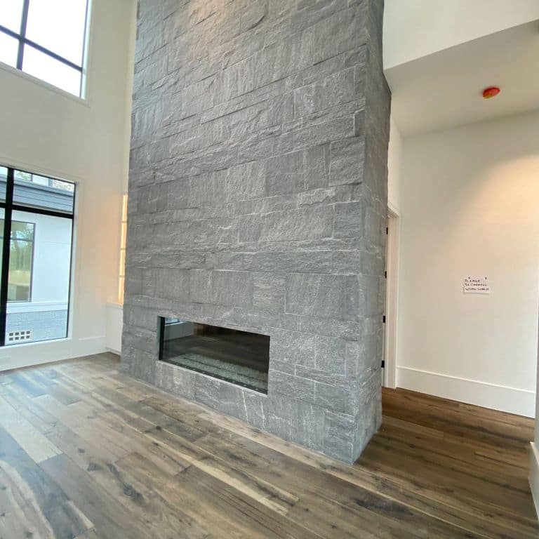 Application image for Brazilian Lucerna Gneiss - Interior Wall Cladding. The image shows this product being used for fireplace surround and interior cladding. The surface finish shown is split-face. The dominant color shown is gray. The color mix creates a cool feeling.