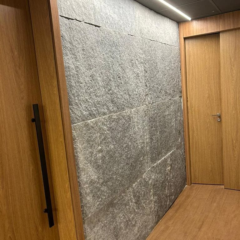 Application image for Brazilian Lucerna Gneiss - Interior Wall Cladding. The image shows this product being used in an interior cladding application. The surface finish shown is split-face. The dominant color shown is gray. The color mix creates a warm feeling.