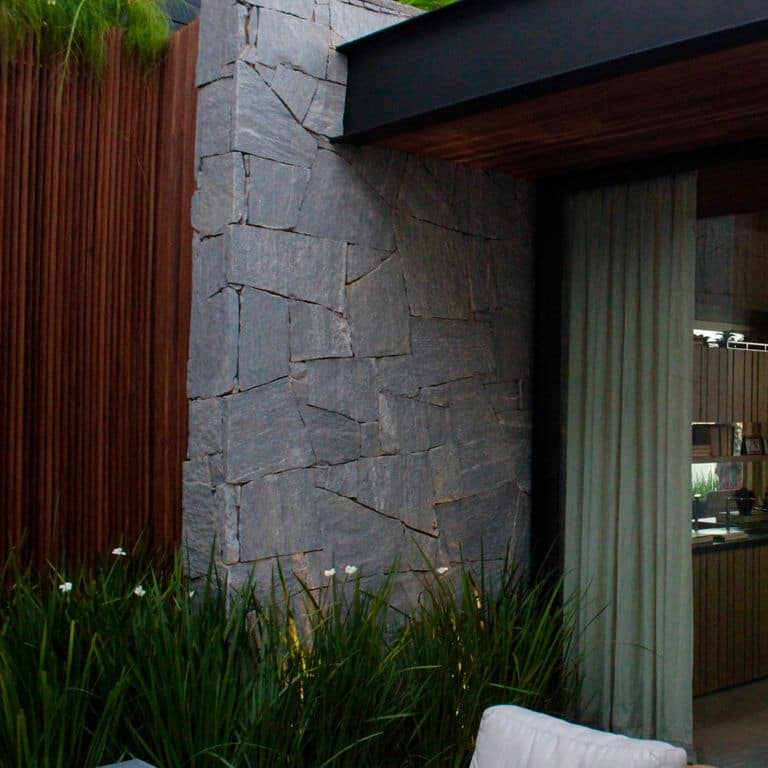 Application image for Brazilian Lucerna Gneiss - Veneer. The image shows this product being used in a full bed veneer application. The surface finish shown is split-face. The dominant color shown is gray.