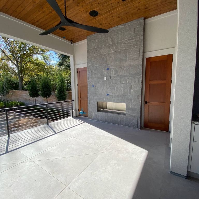 Application image for Brazilian Lucerna Gneiss - Veneer. The image shows this product being used for fireplace surround and thin veneer. The surface finish shown is split-face. The dominant color shown is gray. The color mix creates a cool feeling.