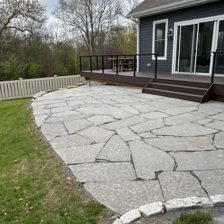 Feature image for Madison Limestone - Irregular Pavers. The image shows this product being used in a patio pavers application. The surface finish shown is flamed. The dominant color shown is gray. The color mix creates a warm feeling.