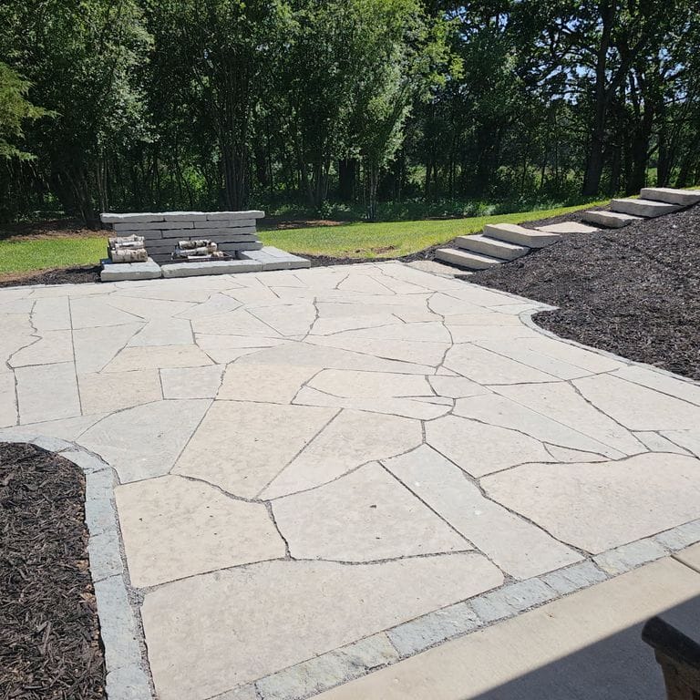 Application image for Madison Limestone - Irregular Pavers. The image shows this product being used in a patio pavers application. The surface finish shown is flamed. The dominant color shown is gray. The color mix creates a cool feeling.