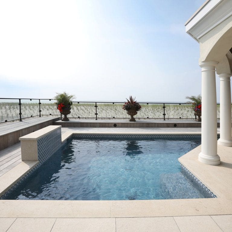 Application image for Veneto Beige Limestone - Pool Coping. The image shows this product being used for pool coping and pool deck pavers. The surface finish shown is flamed. Dominant colors shown are beige, tan and cream. The color mix creates a cool feeling.