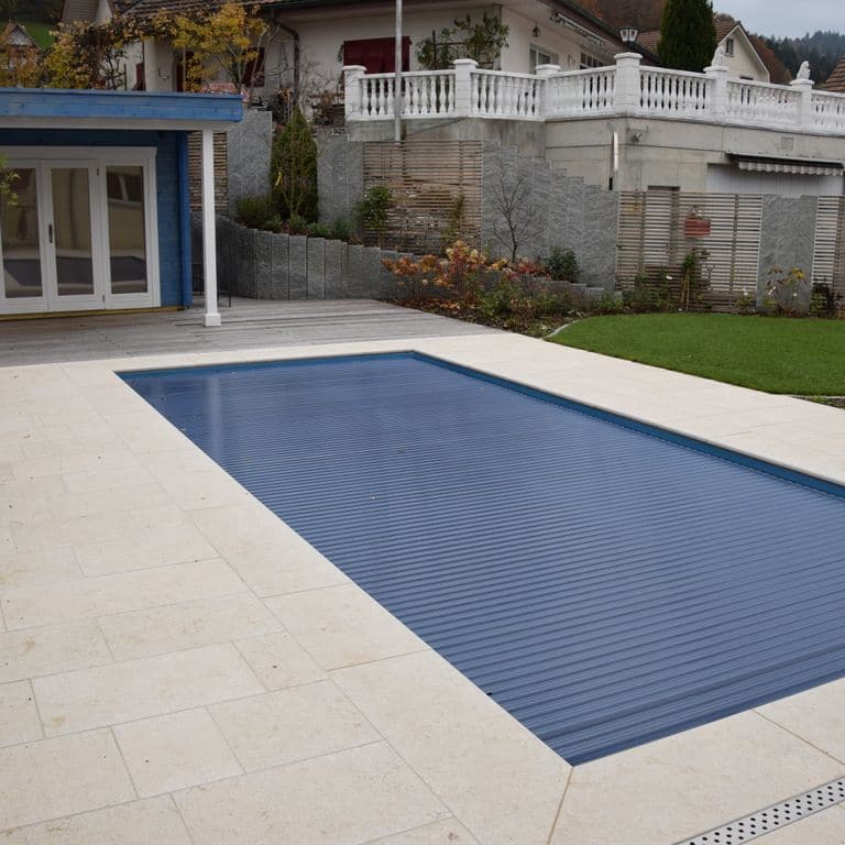 Application image for Veneto Beige Limestone - Pool Coping. The image shows this product being used for pool coping and pool deck pavers. The surface finish shown is flamed. Dominant colors shown are beige, tan and cream. The color mix creates a warm feeling.