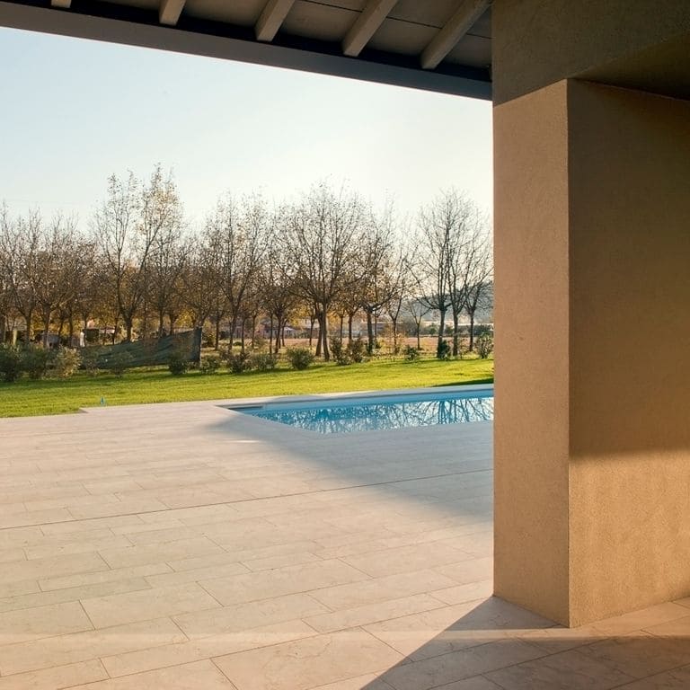 Application image for Veneto Beige Limestone - Pool Coping. The image shows this product being used for pool coping and pool deck pavers. Dominant colors shown are beige, tan and cream. The color mix creates a warm feeling.